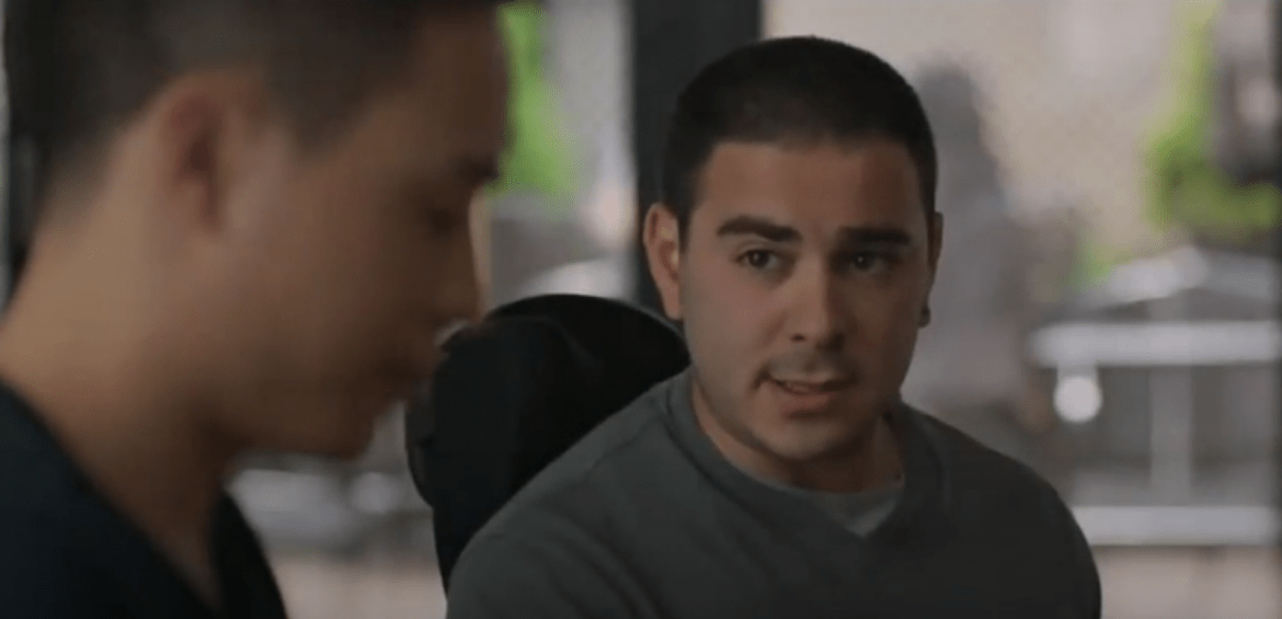 Two men in wheelchairs face each other while inside a house. They are speaking to one another in a screenshot for the film, Come As You Are