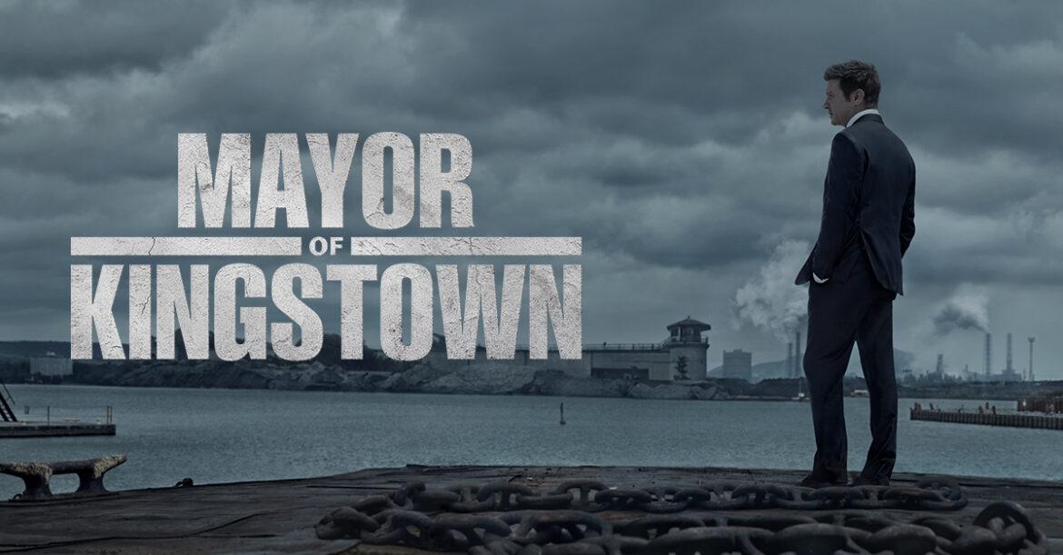 Mayor-of-Kingstown A man stands overlooking the water with some buildings in the background. White text reads "Mayor of Kingstown"