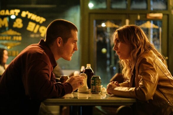 A man and a woman at a table in a restaurant, speaking to each other.